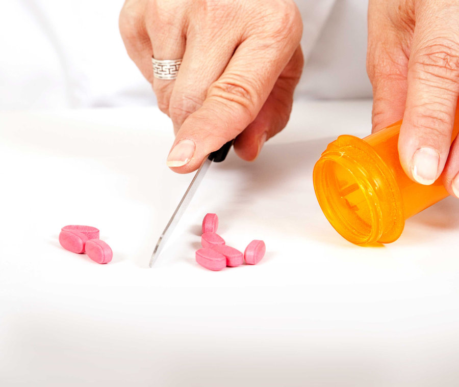 Pharmacist cutting pills